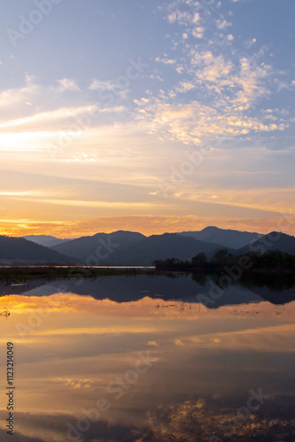 Wallpaper Mural Serene sunset over a tranquil lake, with vibrant colors reflecting on the water and mountains in the background. Torontodigital.ca