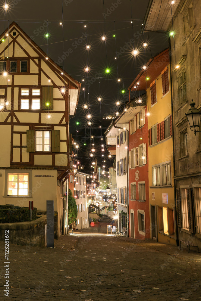 Fototapeta premium a historic house in the old town of Baden, Switzerland. Many installed light bulbs as a christmas decoration