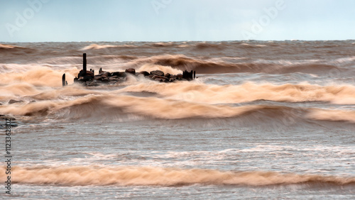 Photography dramatic storm in the Baltic Sea, large waves crashing against the stone pier, b