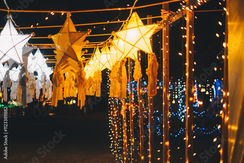 Hanging gold or yellow and white star lanterns as park decoration this Christmas holiday and yuletide season 