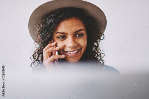 Happy emotional hipster girl feeling excited from friendly conversation via smartphone device, cheerful dark skinned woman in hat calling via mobile phone using wireless 4g connection indoors photo