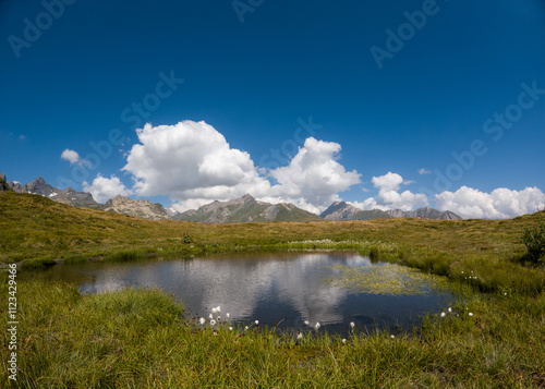 Alps pond reflect clouds mountains background col petit saint bernard