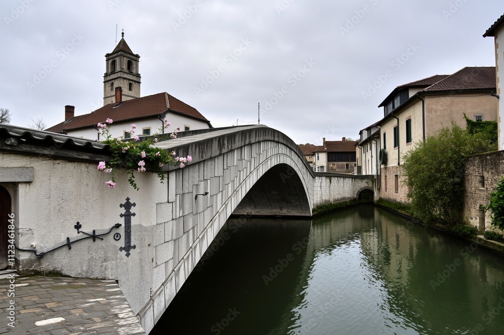 Fototapeta premium Charming Historic Bridge Over a Serene Waterway in a Quaint Italian Town