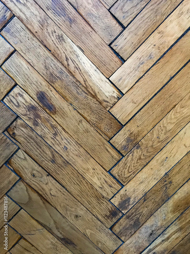 Texture of requiring repair, old worn herringbone parquet floor, close up, vertical