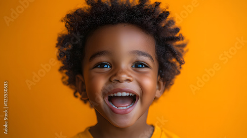 a joyful African American boy radiating excitement, his mouth wide open in an exuberant expression, set against a vibrant orange background.