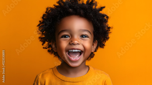 a joyful African American boy radiating excitement, his mouth wide open in an exuberant expression, set against a vibrant orange background.