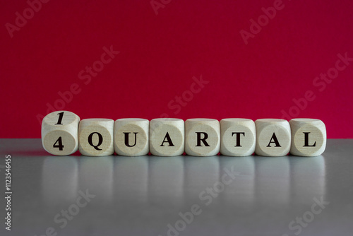 Turned a cube and changes the German expression '4 Quartal' (fourth Quarter) to '1 Quartal' (first quarter). Beautiful red background, grey table. Business concept. photo