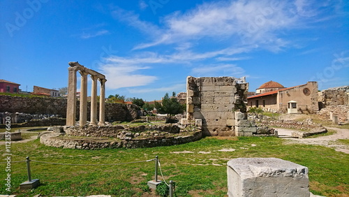 Athens, Greece - 30.3.2018: Standing columns and broken walls in Roman Agora among grass under a sunny blue sky in winter before the pandemic with no tourists photo