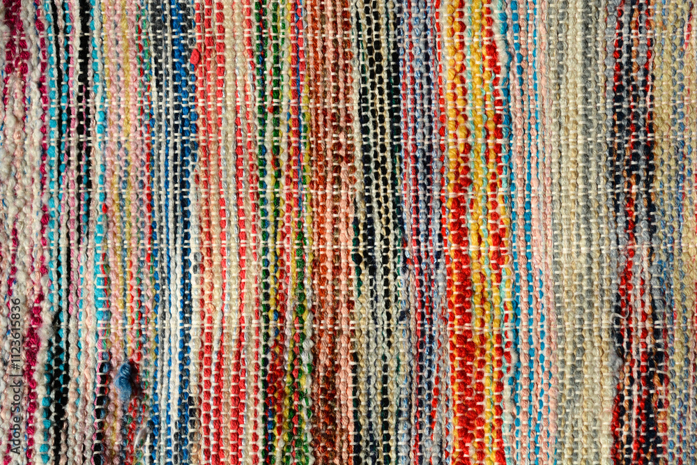 Obraz premium A close-up of a colorful, handcrafted rug woven from various recycled materials, showcasing its unique texture and vibrant patterns