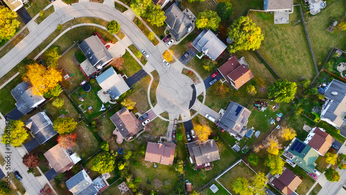 Aerial View of Suburban Cul-de-Sac Neighborhood. A top-down view of a suburban cul-de-sac neighborhood showcasing houses, lawns, driveways, and autumn trees in vibrant colors.