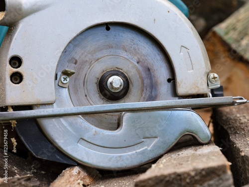 Close-up shot of a circular saw lying on wooden planks. photo