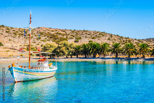 Fishing boat on azure sea and palm trees on idyllic Panormos beach, Naxos island, Cyclades, Greece