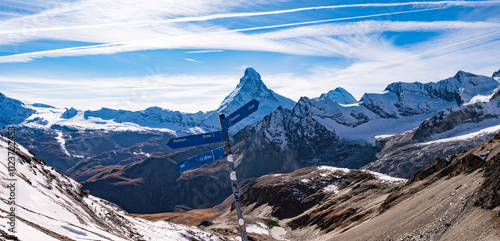 Signs showing hiking directions in the Swiss mountains with Matterhorn peak in the background