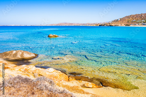 Rocks and stones on idyllic sandy beach of Orkos bay and calm crystal clear azure sea water, Naxos island, Cyclades, Greece