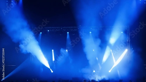 A vibrant stage lit with bright beams of light and a smoky ambiance, symbolizing live performance, entertainment, and artistic expression. photo