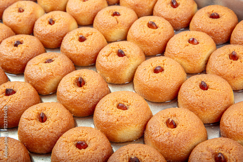 Sekerpare dessert tray. Sekerpare dessert in bulk on a tray. Traditional Turkish cuisine flavors. Turkish Ramadan dessert Sekerpare on a white background. photo