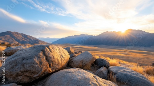 A breathtaking mountain landscape at sunrise, featuring rocky foregrounds and expansive golden plains, Ideal for outdoor, travel, and nature themes in marketing materials, websites, or calendars, photo