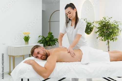 Handsome middle-aged man enjoying relaxing spa massage with oils photo