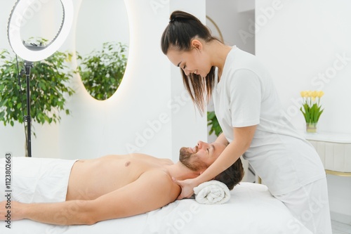 Handsome middle-aged man enjoying relaxing spa massage with oils photo