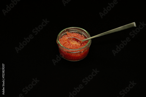 Obraz na płótnie red lumpfish roe in a glass jar isolated on black w salonie