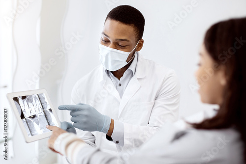 Dentist Doctor Demonstrating Female Patient Teeth Xray Picture On Digital Tablet During Check Up In Modern Stomatological Clinic, Professional Orthodont Discussing Treatment With Young Woman photo