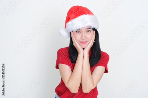 A woman wearing christmas hat smiling happy while wishing something photo