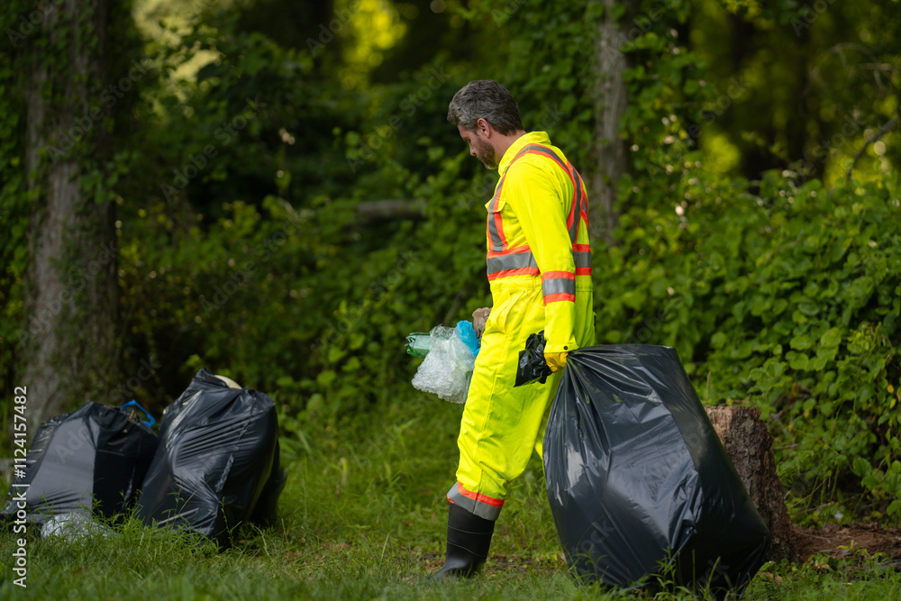 Volunteer man collecting garbage, picking up waste at nature. Land ...