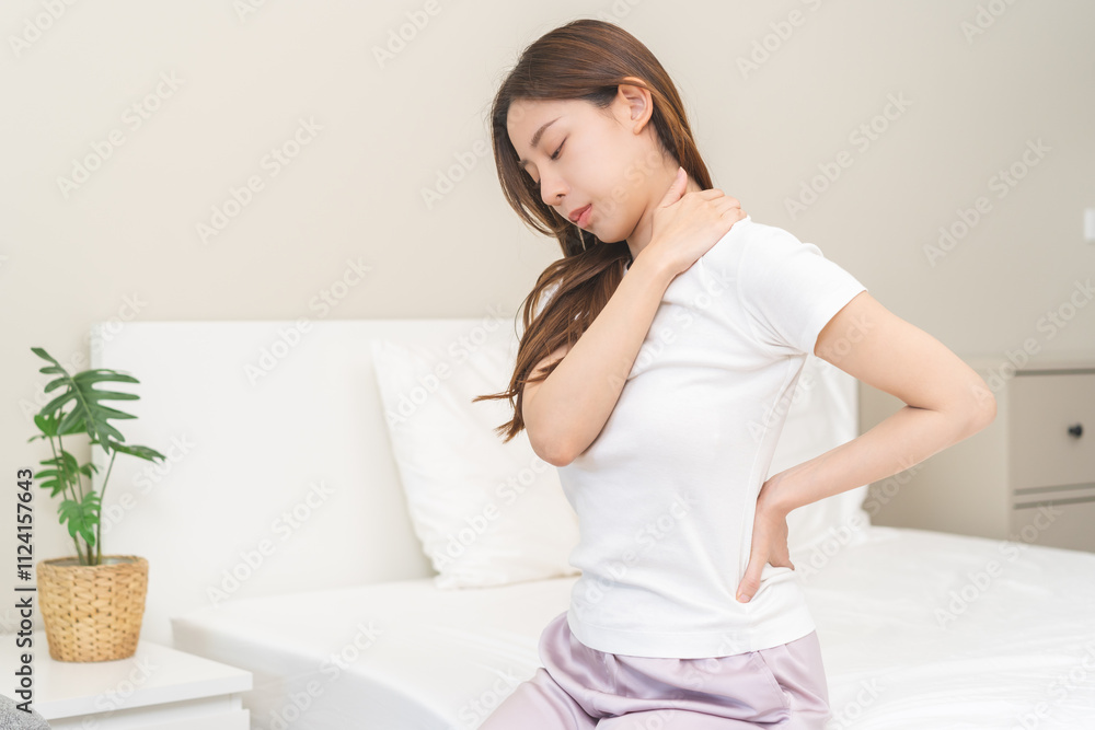 Pain body muscles stiff problem, asian young woman painful with back, neck ache from work hand holding massaging rubbing shoulder hurt, sore sitting on bed in room at home. Health care and medicine. Pain body muscles stiff problem, asian young woman painful with back, neck ache from work hand holding massaging rubbing shoulder hurt, sore sitting on bed in room at home. Health care and medicine.