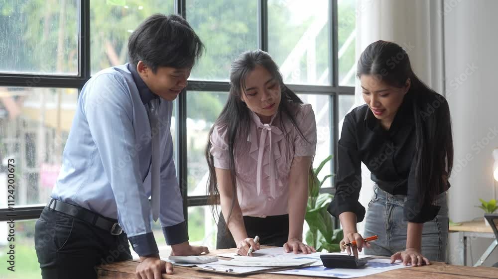 Three people are sitting at a table, discussing something. One of them is pointing at a piece of paper Three people are sitting at a table, discussing something. One of them is pointing at a piece of paper