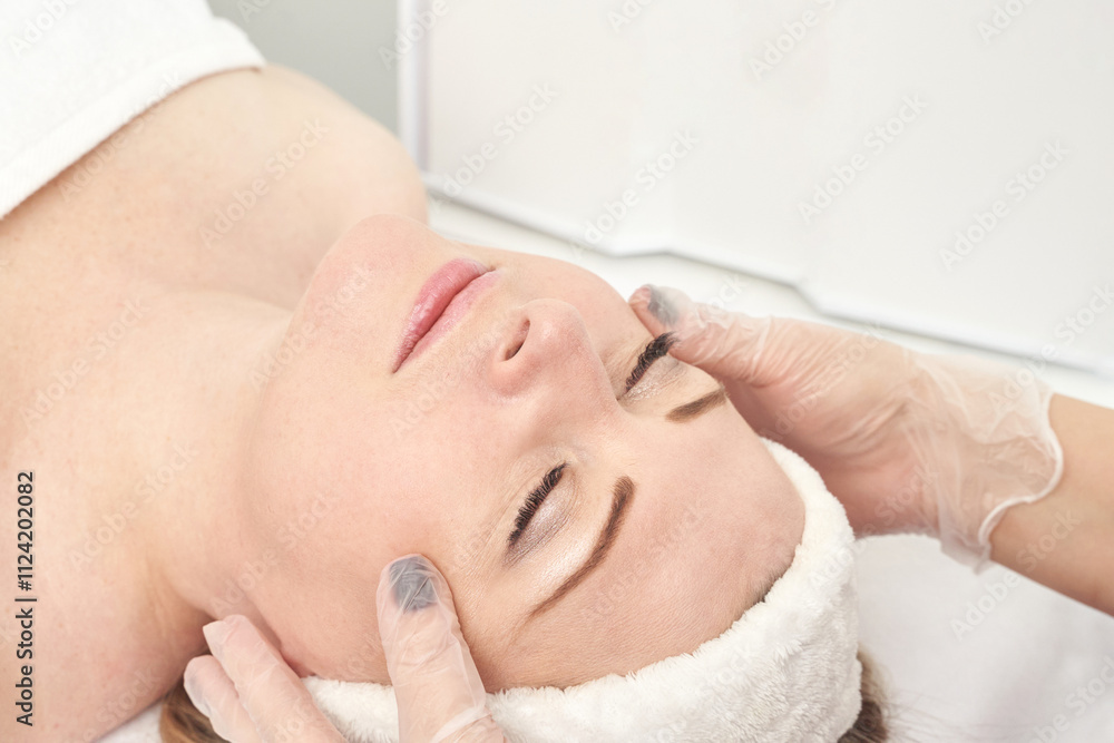 Young caucasian woman receiving facial massage in spa treatment for relaxation and skincare. Young caucasian woman receiving facial massage in spa treatment for relaxation and skincare.