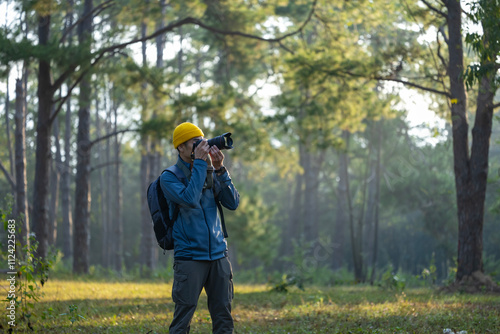 Photographer is taking photo of the new discovering bird species while exploring in the pine forest for surveying and locating rare biological diversity and ecologist on field study photo