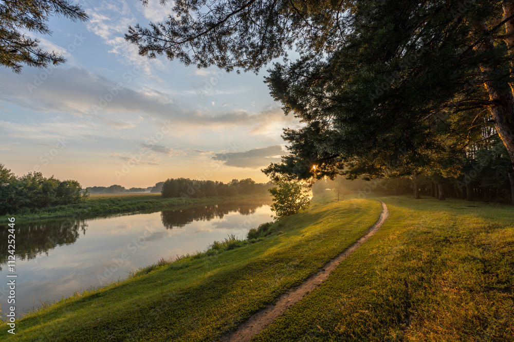 Peaceful scene of a river with a path running alongside it Peaceful scene of a river with a path running alongside it