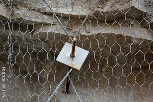 Rock sliding prevention. Mesh net and mutiple strong nails help to catch loosened rocks and boulders from steep slopes photo