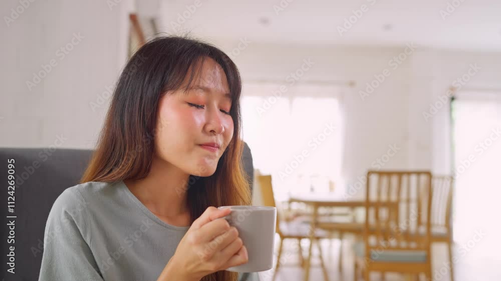 Asian young beautiful woman drinking a cup of hot coffee in house. Asian young beautiful woman drinking a cup of hot coffee in house.