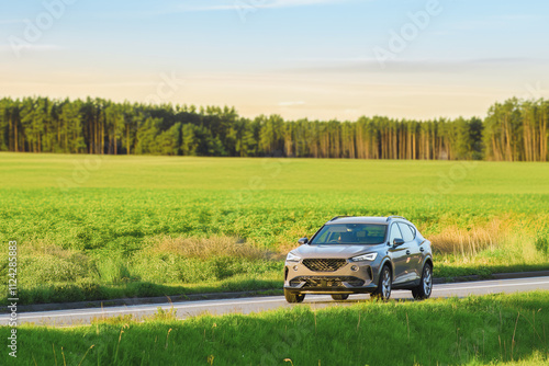 Stylish European crossover on rural road during sunset photo