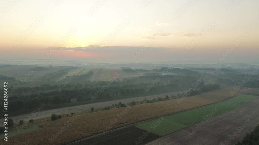 Sunlight breaking through morning mist over farmland Sunlight breaking through morning mist over farmland