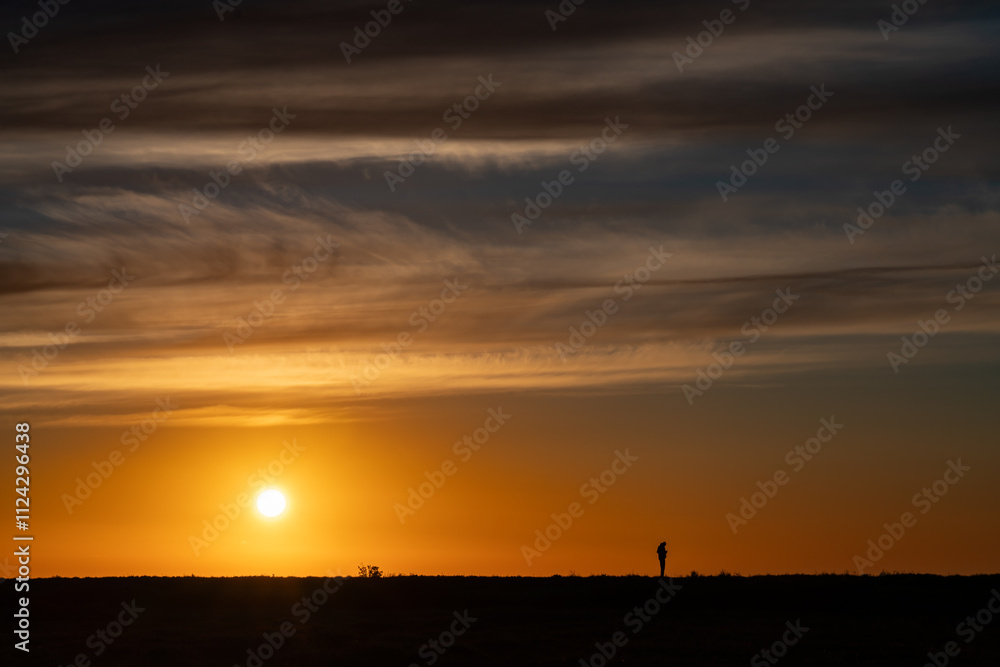 Silhouette of person on hill at sunrise Silhouette of person on hill at sunrise