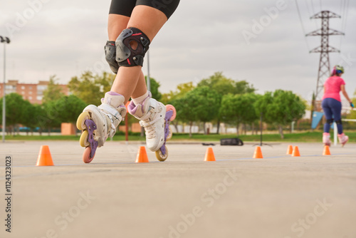 Фотография Close-up of legs practicing rollerblading slalom with protective gear