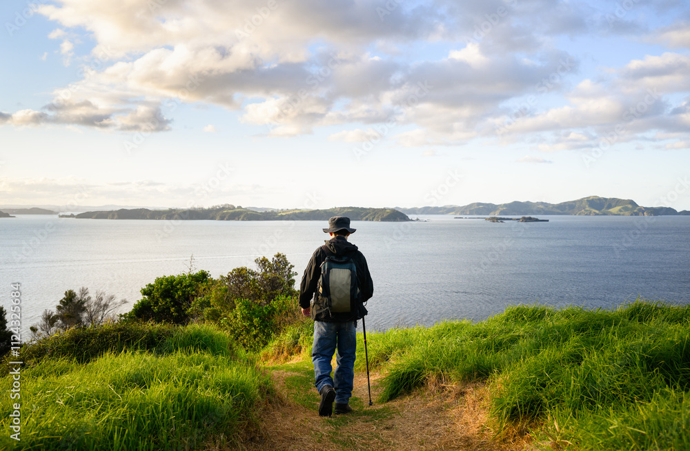 Man walking on Tapeka Point Track at sunset. Russell. Bay of Islands.