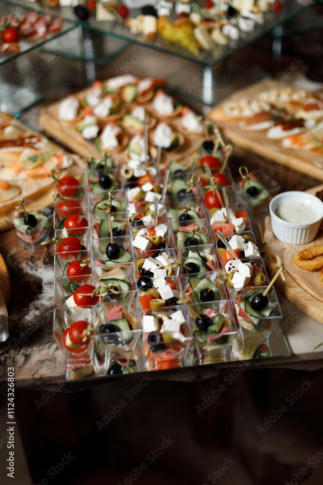 a variety of snacks presented in the form of canapés and small portions in clear plastic cups. a variety of snacks presented in the form of canapés and small portions in clear plastic cups.