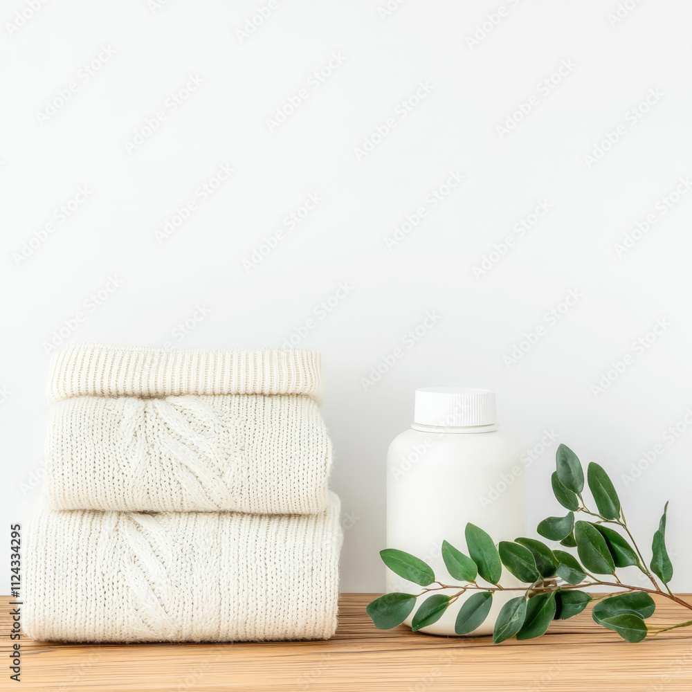 A serene arrangement of stacked towels next to a bottle and a sprig, creating a calming, minimalist aesthetic. A serene arrangement of stacked towels next to a bottle and a sprig, creating a calming, minimalist aesthetic.