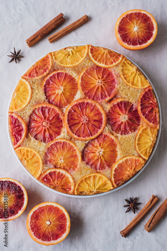 Delisious freshly baked homemade blood orange upside-down cake, top view on neutral background. Popular winter holiday dessert.