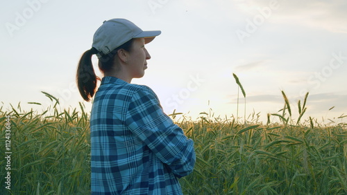 Female Farmer Outdoors In Summer. Woman Agronomist Farmer Stands And Checks Harvest In Wheat Field. Happy Female Farmer. Concept Of Agriculture. Gimbal shot.
