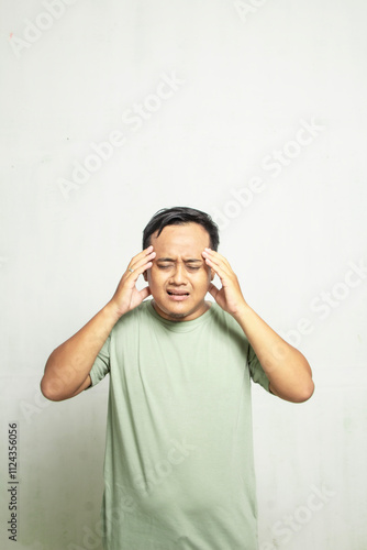 Asian man with glasses holding dizzy head isolated on white background