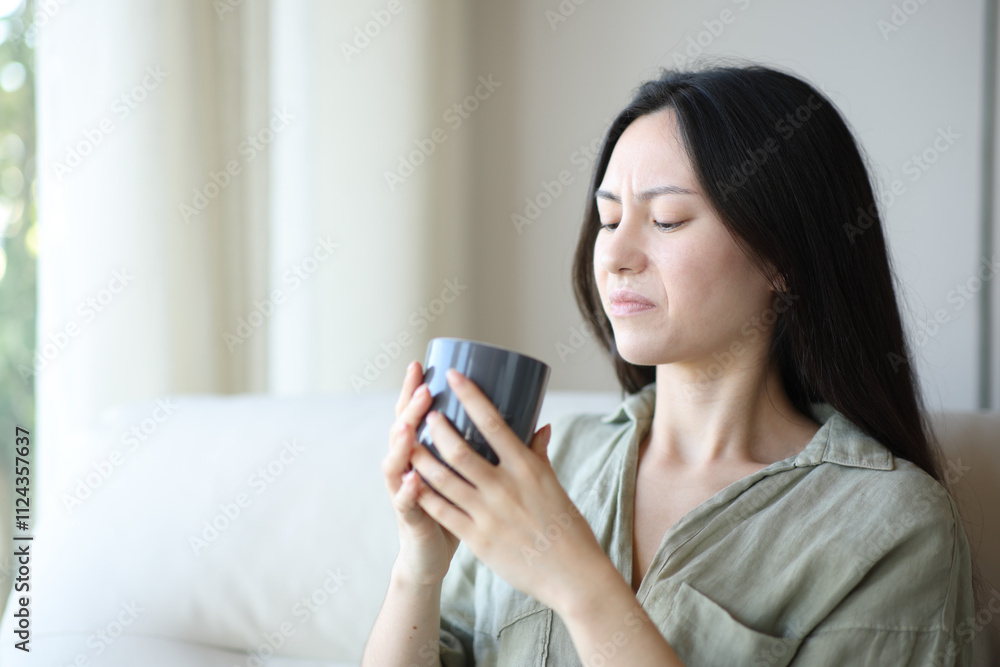 Disgusted asian woman drinking coffee Disgusted asian woman drinking coffee