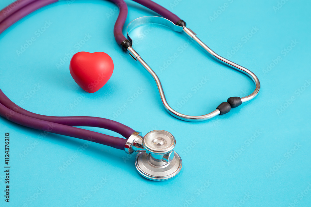Image of a purple stethoscope with a red heart on a blue background Image of a purple stethoscope with a red heart on a blue background