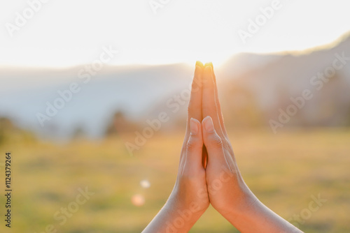 Closeup Young woman hands place together like praying worship at sunset.worship god with christian concept religion. photo