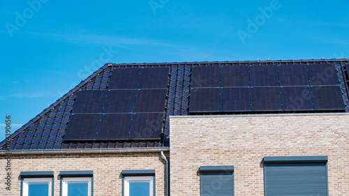 Newly built houses with black solar panels on the roof, Close up of new building with black solar panels. Zonnepanelen, Zonne energie, Translation: Solar panel, Sun Energy