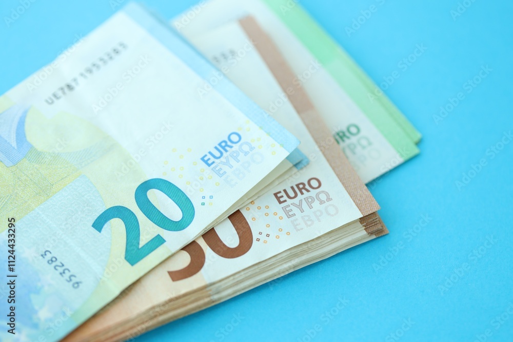 Big amount of one hundred, twenty and fifty euro money bills on blue background Big amount of one hundred, twenty and fifty euro money bills on blue background