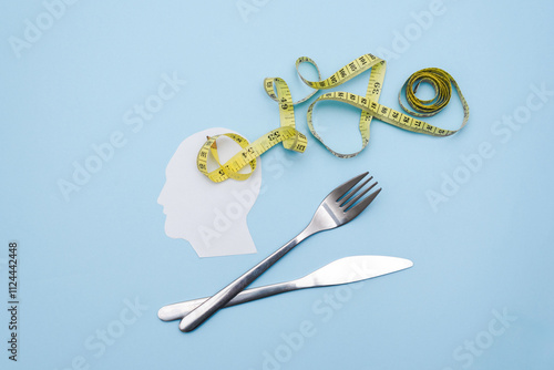 Bild auf Leinwand Silhouette paper Head, Yellow Measuring Tape and Silver Fork and Knife on Blue B